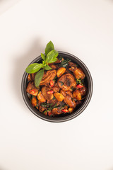 Three cups chicken dish on white