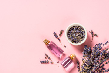 Lavender essential oil and perfume on pink.