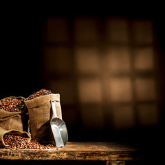 Grains de café frais dans un sac et un intérieur sombre avec des sadows. Copiez l& 39 espace pour votre décoration.