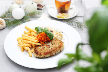 Cauliflower cutlet served with fries and carrot and celery salad. Appetizing dish. Ready meal on a plate. Suggestion of serving food.