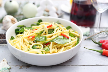 Spaghetti pasta with spinach and chili pepper. Appetizing dish. Ready meal on a plate. Suggestion of serving food.