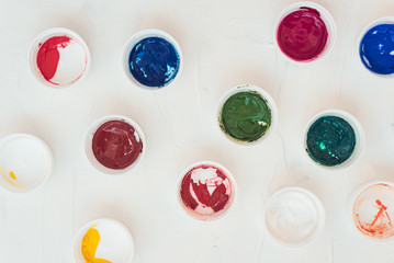 Can covers with paints, abstract pattern background. Flat lay, top view