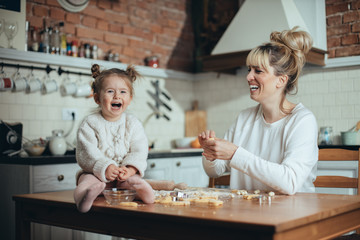 Mother and daughter baking cookies in their kitchen