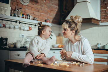 Fototapeta premium Mother and daughter baking cookies in their kitchen