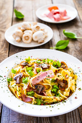 Tagliatelle with ham and chmpignon wooden table