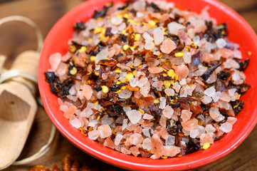 Fototapeta na wymiar Pink himalayan salt chrystals with dried seeds of red hot chili peppers and herbs
