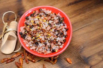 Pink himalayan salt chrystals with dried seeds of red hot chili peppers and herbs