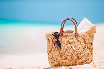 Beach accessories - straw bag, hat and unglasses on the beach