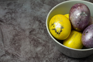 Easter colored eggs in a plate on a gray background