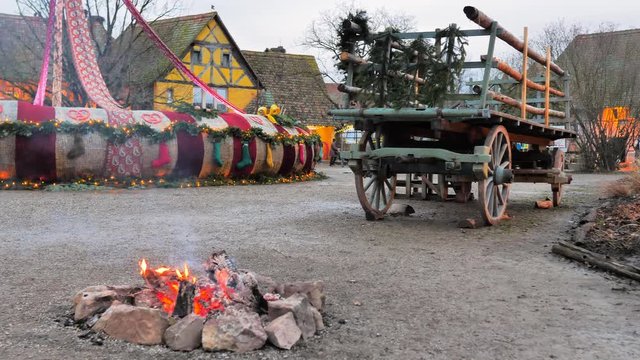 Carruaje de madera junto a fuego en aldea de colores y madera