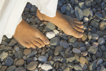 Feet of young woman on pebble beach