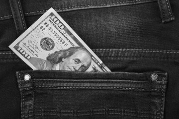 One hundred dollar banknote money in pocket jeans pants background texture. 100 dollar bill close up