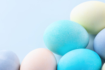 Colorful Easter eggs dyed by colored water isolated on a pale blue background, design concept of Easter holiday activity, close up, copy space.