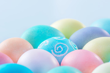 Fototapeta na wymiar Colorful Easter eggs dyed by colored water isolated on a pale blue background, design concept of Easter holiday activity, close up, copy space.