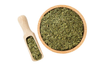 dried lovage herb in wooden bowl and scoop isolated on white background. front view. spices and food ingredients