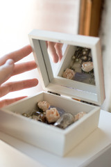 Closeup hand holds vintage casket of secrets with mirror, flowers, keys and small glass jars