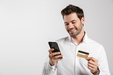 Businessman using mobile phone holding credit card.