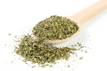 dried lovage herb in wooden spoon isolated on white background. spices and food ingredients. spices and food ingredients