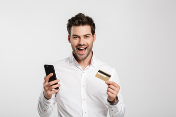 Businessman using mobile phone holding credit card.