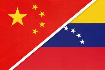 China or PRC vs Venezuela national flag from textile. Relationship between asian and american countries.