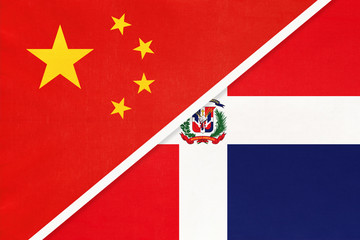 China or PRC vs Dominican Republic national flag from textile. Relationship between asian and american countries.