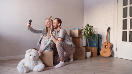 Young married couple calls friends or relatives via video, moves to a new apartment or city