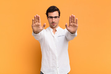  looking serious, unhappy, angry and displeased forbidding entry or saying stop with both open palms