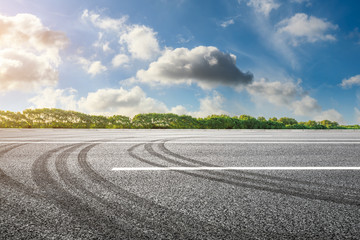 Fototapeta premium Asphalt road and green woods background