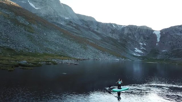 Young Woman on Paddle Board in Alpine Lake Under Mount Evans Byway. Aerial View, Summit Lake Park,Colorado USA