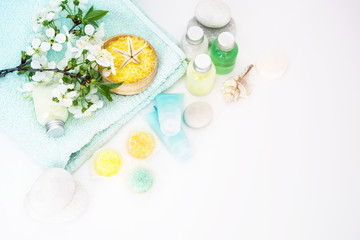 Obraz na płótnie Canvas Care of a body. Aromatic salt for Spa therapies, cosmetics for a body and acceptance of bathtubs, towel and a spring flower on white background