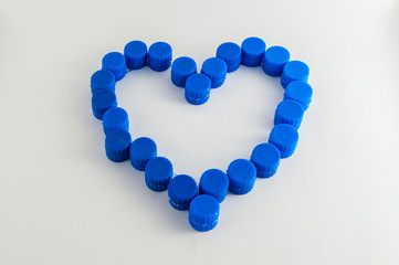 heart made of blue plastic caps, isolated on white background
