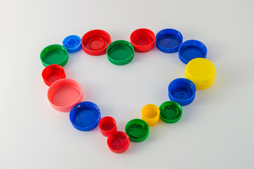heart made of colorful plastic caps, isolated on white background