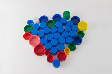 heart made of colored plastic caps and blue interior, isolated on white background