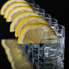 The bartender pours a strong liquor into small glasses, such as tequila alcoholic drinks or spirits.