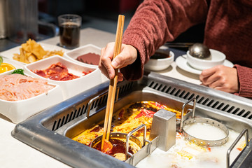 Chinese Hotpot shabu spicy and sour soup with meat and seafood, Suki Chinese style - selective focus