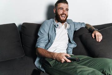 Attractive young bearded man relaxing on a couch at home