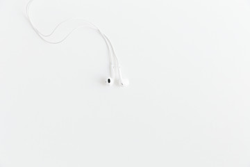 White earphones on the white background.Space for text,mockup.Minimalism.