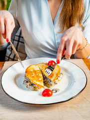 woman eating potato pancake with meat