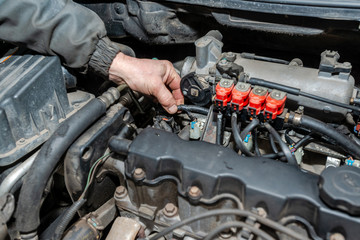 Machanic repairman at the LPG converted engine. Disassembled motor vehicle for repair