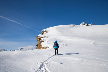 Fototapeta na wymiar man trekking in snow in the Swiss Alps
