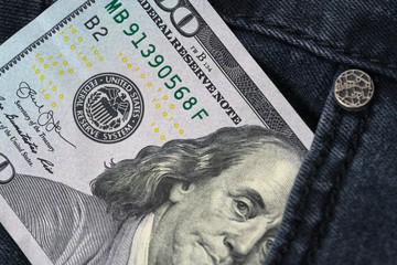 One hundred dollar banknote money in pocket jeans pants background texture. 100 dollar bill close up