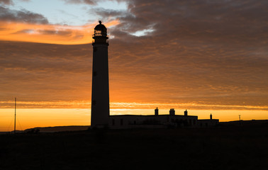 lighthouse silhouette at sunrise