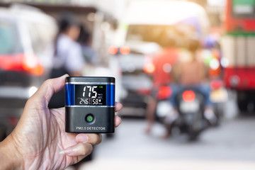 hand holding PM 2.5 Detector over smog city from PM2.5 dust. Air pollution, Love health concept