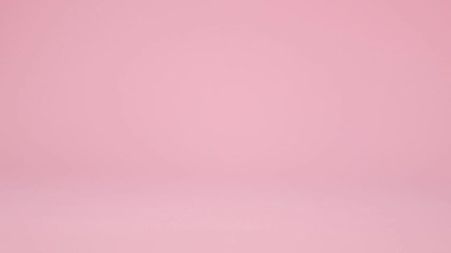 Model red toy car with a golden egg on the hood on a pink background. Gift delivery. Happy easter concept