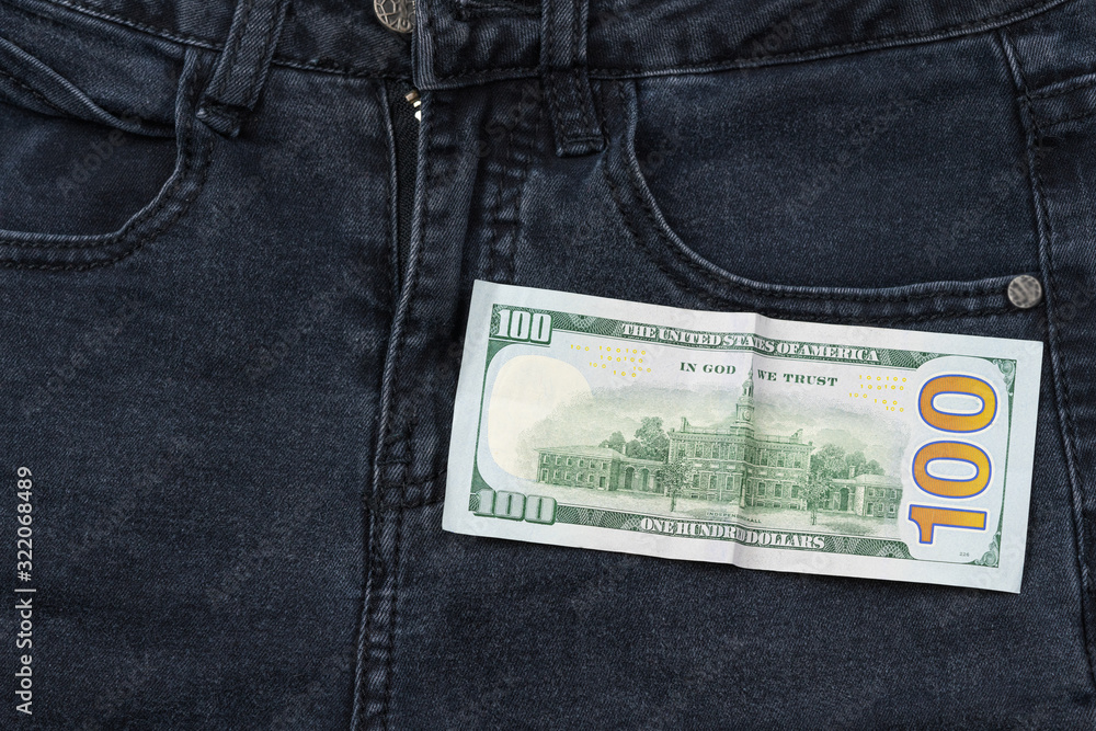 Wall mural One hundred dollar banknote money in pocket jeans pants background texture. 100 dollar bill close up