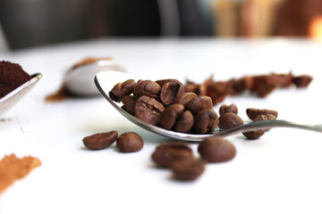 brown roasted coffee bean with tea spoon on white background. coffee beans in a spoon isolate