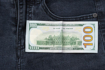 One hundred dollar banknote money in pocket jeans pants background texture. 100 dollar bill close up