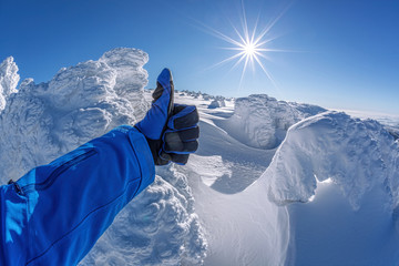 hand shows thumbs up against winter landscape