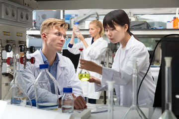 Obraz premium Modern Caucasian and Asian students at lab