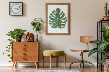 Vintage interior design of living room with design retro furnitures, plants, shelf, black clock and brown poster mock up frame on the beige wall. Stylish home decor. Template. 